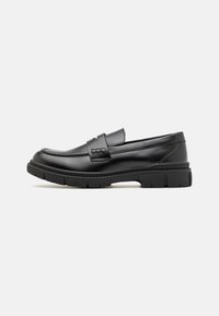 Schwarze Lederloafer mit einem breiten Riemen über dem Rist, Gummisohle mit dicken Profilen und glatter Textur. Klassisches, schlankes Design.