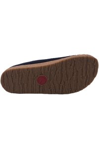 Semelle de chaussure en caoutchouc marron avec un motif texturé, dotée d'un logo d'accent rouge. Le bord supérieur semble doux avec une forme arrondie et une couleur sombre.