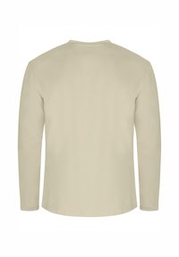 Langarmhemd in hellem Beige, aus weicher Baumwolle gefertigt. Verfügt über einen klassischen Rundhalsausschnitt und schlichte Steppnähte entlang der Nähte.