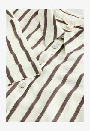 Chemise en lin à boutons présentant des rayures alternées crème et marron, un col et des boutons clairs. Tissu doux et texturé.