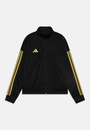 Svart träningsjacka med guld tre-randsdesign på ärmarna, hög krage, dragkedja framtill och två sidofickor. Slät textur, atletisk passform.