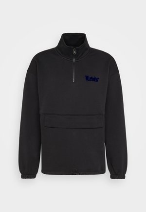 Pull en polaire noir avec un col haut et une fermeture éclair d'un quart de longueur. Doté d'une poche avant et d'un logo en texte brodé bleu foncé.