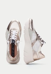 Sneaker in rete metallico oro e argento con lacci bianchi, suola bianca imbottita e logo inciso sulla linguetta e sul tallone.