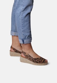 Sandali con zeppa in stampa leopardata e punta scoperta, realizzati in tessuto e con suola avvolta in juta. Design con cinturino regolabile. Stile casual.