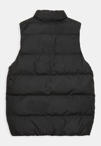 Černá péřová vesta s vysokým límcem, prošívanou strukturou a žádnými viditelnými zapínáními. Hladká tkanina s jemným leskem. Pouze zadní pohled.