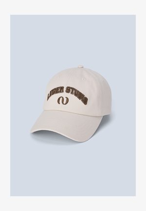 Valge puuvillane pesapallimüts, millel on pruunisäbriga broderitud "LIBER STUDIO". Mütsil on kõver visor ja reguleeritav rihm seljal.