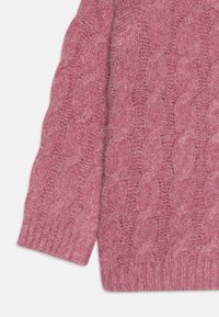 Suéter de punto trenzado en suave lana rosa, con patrones texturizados y puños acanalados. Dobladillo redondeado con una apariencia acogedora y cálida.