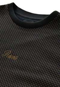 Black and brown checkered tee with a textured surface, featuring a black crew neckline and embroidered "Roma" in gold.