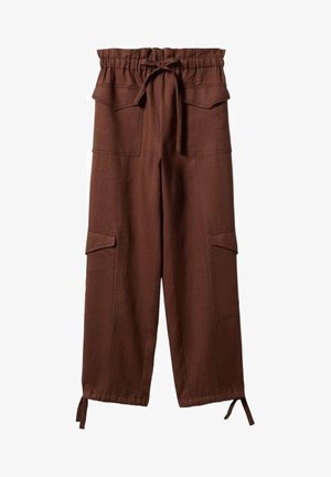 Mujer con suéter negro corto acanalado con botones, pantalones cargo marrones de cintura alta con lazos en los tobillos y sandalias negras de punta abierta, de pie.