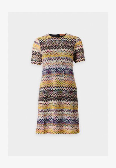 Robe à manches courtes avec motif zigzag multicolore en jaune, noir, rose, bleu et blanc sur fond clair.