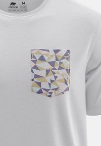 Camiseta blanca de algodón con un diseño de bolsillo geométrico en colores pastel que incluye triángulos en púrpura, dorado, azul y rosa, con bordes cosidos.