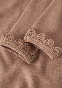 Zachte, gestructureerde roze stof met een keperpatroon. De mouwen hebben decoratieve kanten rand met bloemmotieven langs de boorden.