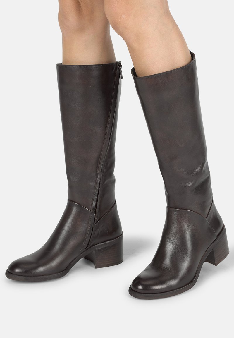 Bottes en cuir marron à hauteur de genou avec un talon carré, dotées d'une fermeture éclair sur le côté et d'une texture lisse. Le design comprend un tige ajustée et un bout arrondi.