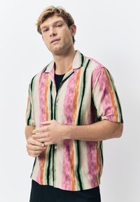 Chemise à manches courtes présentant un motif rayé rose et vert, fabriquée en tissu léger, avec un devant à boutons et une coupe décontractée.