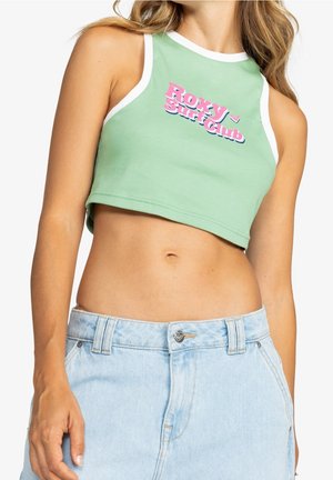 Haut court côtelé vert avec finition blanche, arborant l'inscription "ROXY Surf Club" en lettres roses et bleues, conçu pour le confort et un port décontracté.