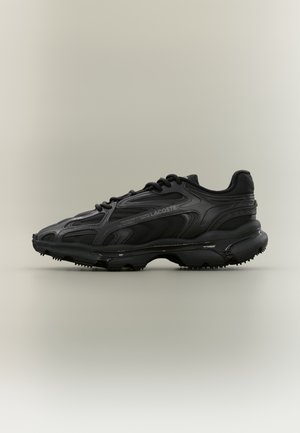 Czarny sportowy sneaker Lacoste z teksturowaną podeszwą, sznurowanym fasonem i subtelnym logo z boku, pokazany z profilu na jednolitym tle.