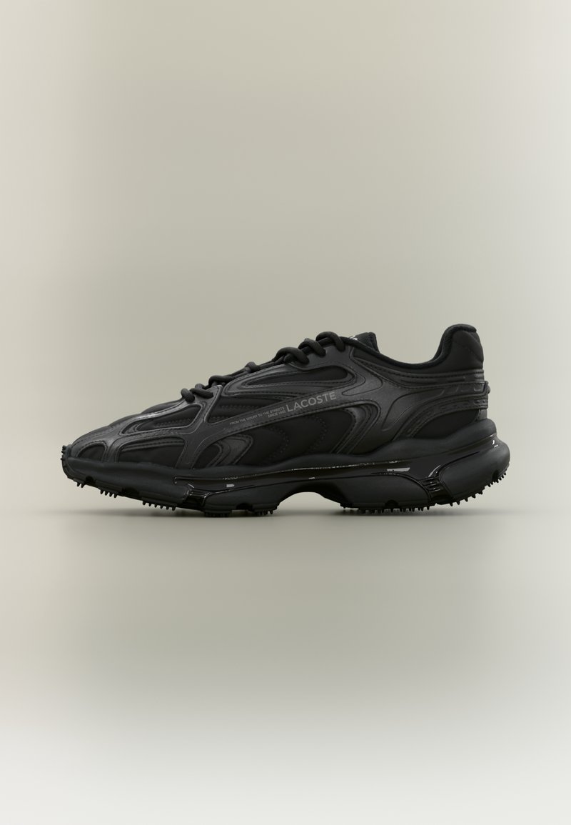 Baskets de sport noires Lacoste avec semelle texturée, design à lacets et marquage subtil sur le côté, présentées de profil sur fond uni.