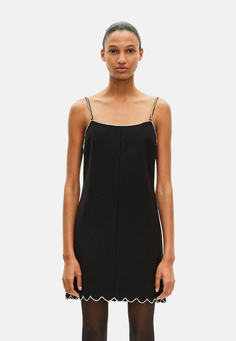 Robe noire sans manches avec ourlet festonné et bordure perlée le long de l'encolure. Confectionnée en tissu lisse avec une silhouette droite.