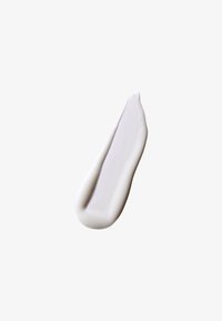 Crème ou lotion blanche étalée en une forme lisse et allongée avec un bord légèrement surélevé et une texture douce et mate.