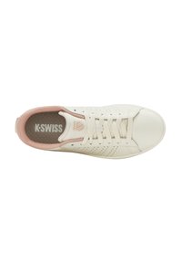 Zapatilla blanca K-Swiss con lados perforados, cordones crema, cuello acolchado rosa y plantilla con logo, vista desde arriba.
