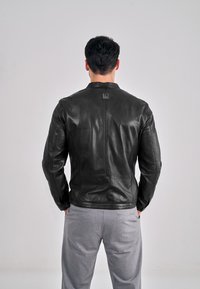 Černá kožená bunda s úzkým střihem, minimalistickým designem s kulatým límcem a jemným logem na horní části zad.