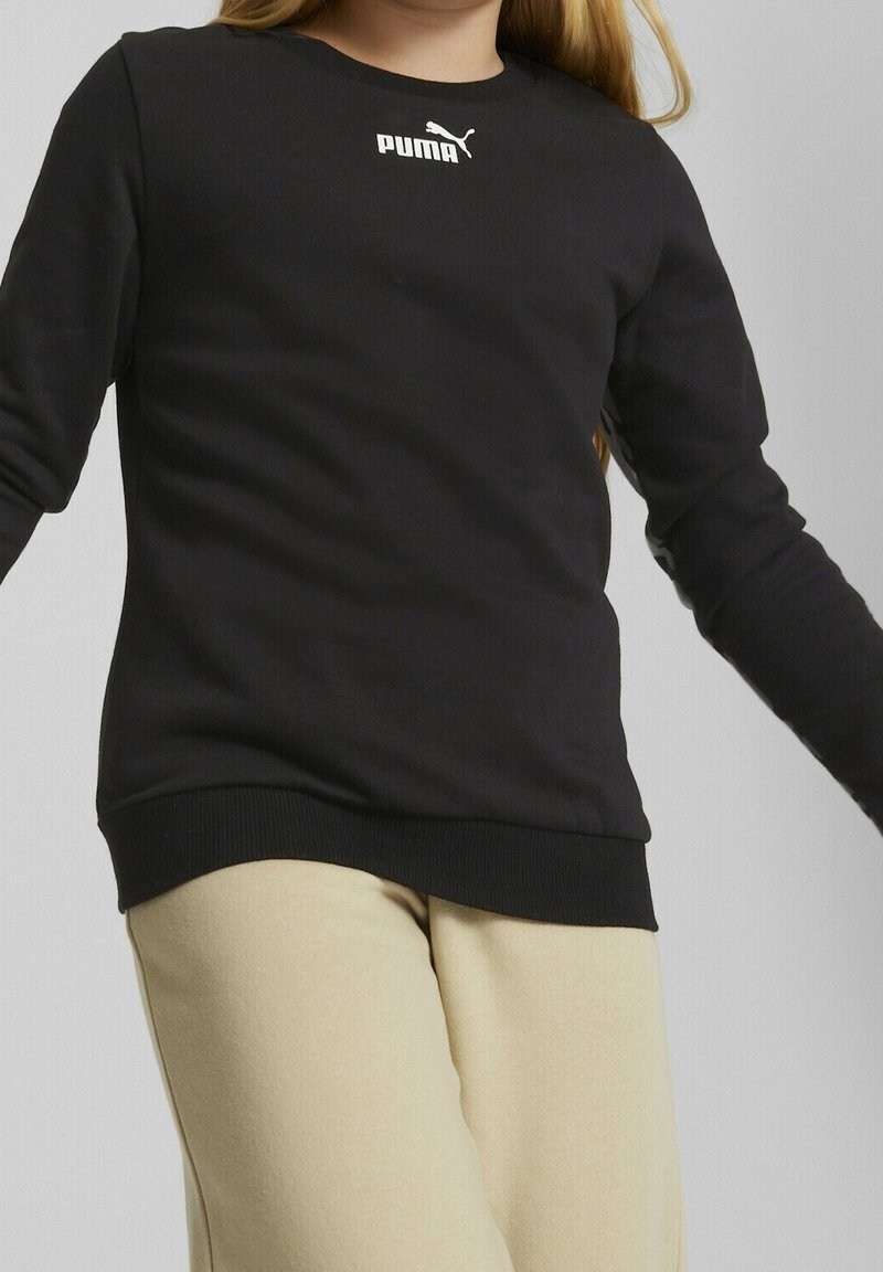 Sweatshirt noir à manches longues en tissu doux, arborant un logo Puma blanc sur la poitrine et des poignets et un ourlet côtelés.