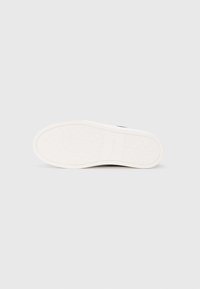 Witte rubberen zool met een gestructureerd grippatroon. Heeft een glad ontwerp en het Calvin Klein-logo is op de zijkant ingebed.