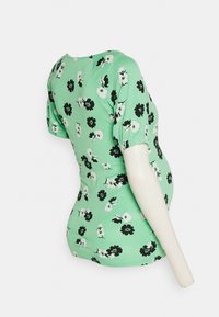 Top floral verde com flores pretas e brancas, mangas curtas e volumosas, design justo e tecido texturizado em um manequim.