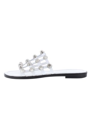 Hvid lav sandal med sort sål, med flere remme pyntet med sølvfarvede runde nitter over toppen.
