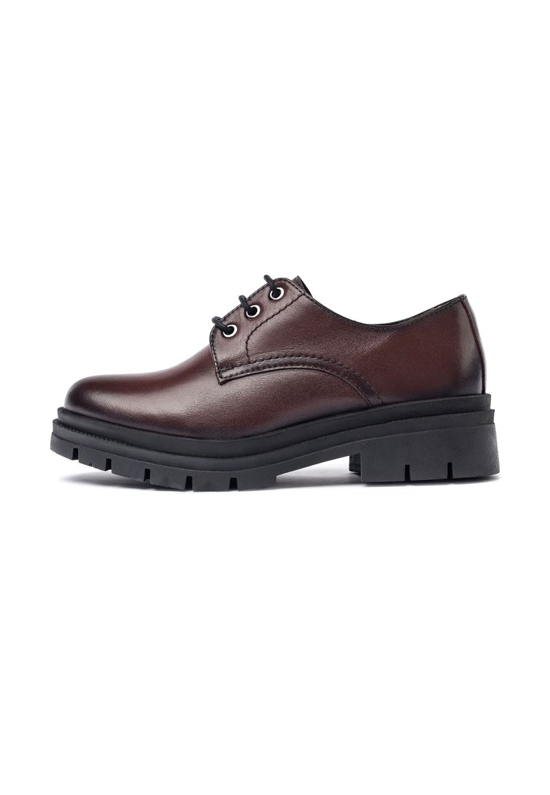 Zapato de piel marrón con cordones y punta redonda, suela de goma negra y acentos texturizados. Presenta ojales para los cordones y detalles cosidos.