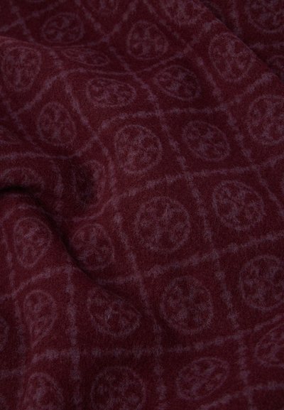 Burgundy tyg med en mjuk, texturerad yta som har ett geometriskt mönster av cirkulära former inom ett rutnät, vilket skapar en subtil kontrast.