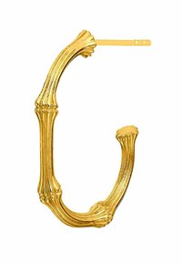 Pendiente de aro dorado con una estructura similar al hueso; presenta nervaduras texturizadas y extremos cónicos, mostrando un diseño orgánico y único.