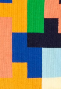 Strickstoff mit abstrakten Farbbereichen in Orange, Blau, Pink, Grün und Schwarz. Verfügt über verschiedene Texturen und ein geometrisches Muster.