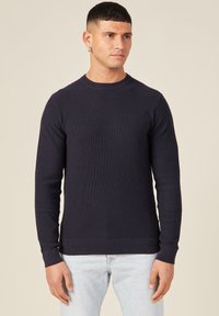 Merihenkinen, ribbed-kudottu neulepaita, jossa on pyöreä kaula-aukko, pitkät hihat ja istuva helma. Kankaan pinnassa on teksturoitu viimeistely ja klassinen leikkaus.