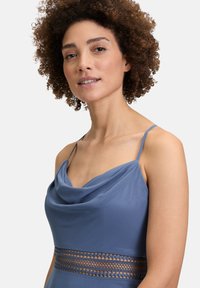 Robe bleue sans manches avec col bateau et bande d'accent texturée. Fabriquée en matériau doux, elle présente des fines bretelles et une silhouette ajustée.