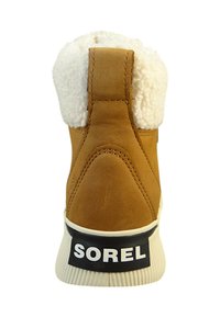 Beige semsket støvel med hvit pelskant, med svart SOREL-logo på hælen, rillede gummisåler og glatt tekstur.