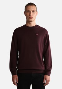 Bordeaux langærmet sweatshirt i blødt stof, med rund halsudskæring, ribbede manchetter og et lille broderet flaglogo på brystet.