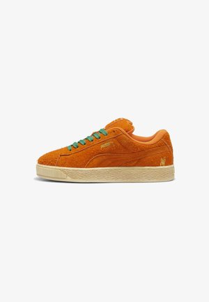 Baskets en daim orange avec lacets verts et accents dorés. Semelle épaisse avec une texture antidérapante. Présente un design minimaliste et des détails de logo.