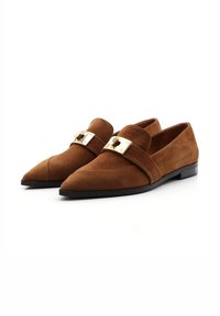 Bruine suède loafers met een puntige neus, voorzien van een brede band versierd met een goudkleurige gesp en een gladde zwarte loopzool.
