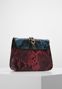 Borsa a tracolla con motivo a serpente colorato, caratterizzata da un design strutturato, squame multicolori in rosso, verde e blu, e una chiusura in hardware dorato.