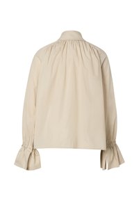 Blouse beige à manches longues avec col froncé et poignets volantés, vue de dos sur fond blanc.