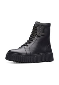 Botas de cuero negro hasta el tobillo con una suela de goma gruesa y estriada, que presentan cordones redondos y una etiqueta de cuero con la marca en el lateral.