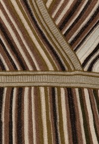 Tessuto a strisce con bande alternate di marrone, crema e verde oliva. La trama è lavorata a maglia con una finitura leggermente lucida e una fascia elastica in vita.