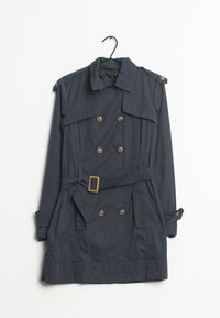 Trench-coat bleu marine avec un design croisé, des boutons en bronze et une ceinture beige. Comprend des épaulettes et deux poches avant.