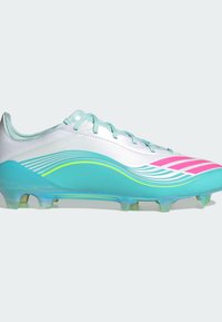 Άσπρο και τιρκουάζ ποδοσφαιρικό παπούτσι με ροζ και κίτρινα κυματιστά σχέδια, ανοιχτά μπλε κορδόνια και διάφανο υπόδημα με καρφιά σε λευκό φόντο.