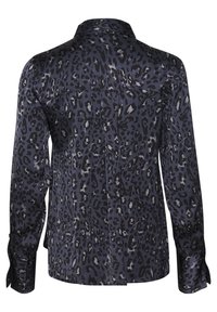 Leopardprint skjorte med knapper i marineblå, sølvfarvede detaljer og lange ærmer. Har en rygsømsyning og manchetter med knapdetaljer. Silkeagtig tekstur.
