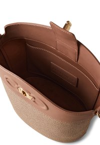 Sac rond en cuir marron clair avec un fond texturé, quincaillerie dorée et poches intérieures. L'intérieur est lisse avec un patch logo.
