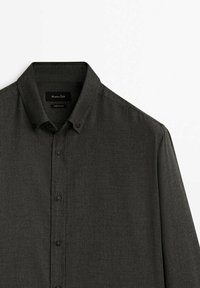 Ciemnoszara koszula zapinana na guziki, charakująca się usztywnionym kołnierzykiem, długimi rękawami i subtelną teksturą. Czarnie guziki uzupełniają ten projekt.