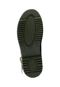 Semelle de chaussure en caoutchouc noir avec un motif texturé et rainuré. Présente un design ovale et un accent doré près du talon.