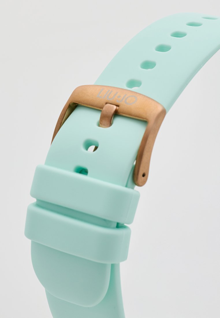 Correa de reloj de silicona color menta con hebilla de metal bronce y logo en relieve "LIU.JO". Presenta múltiples orificios de ajuste para un mejor calce.